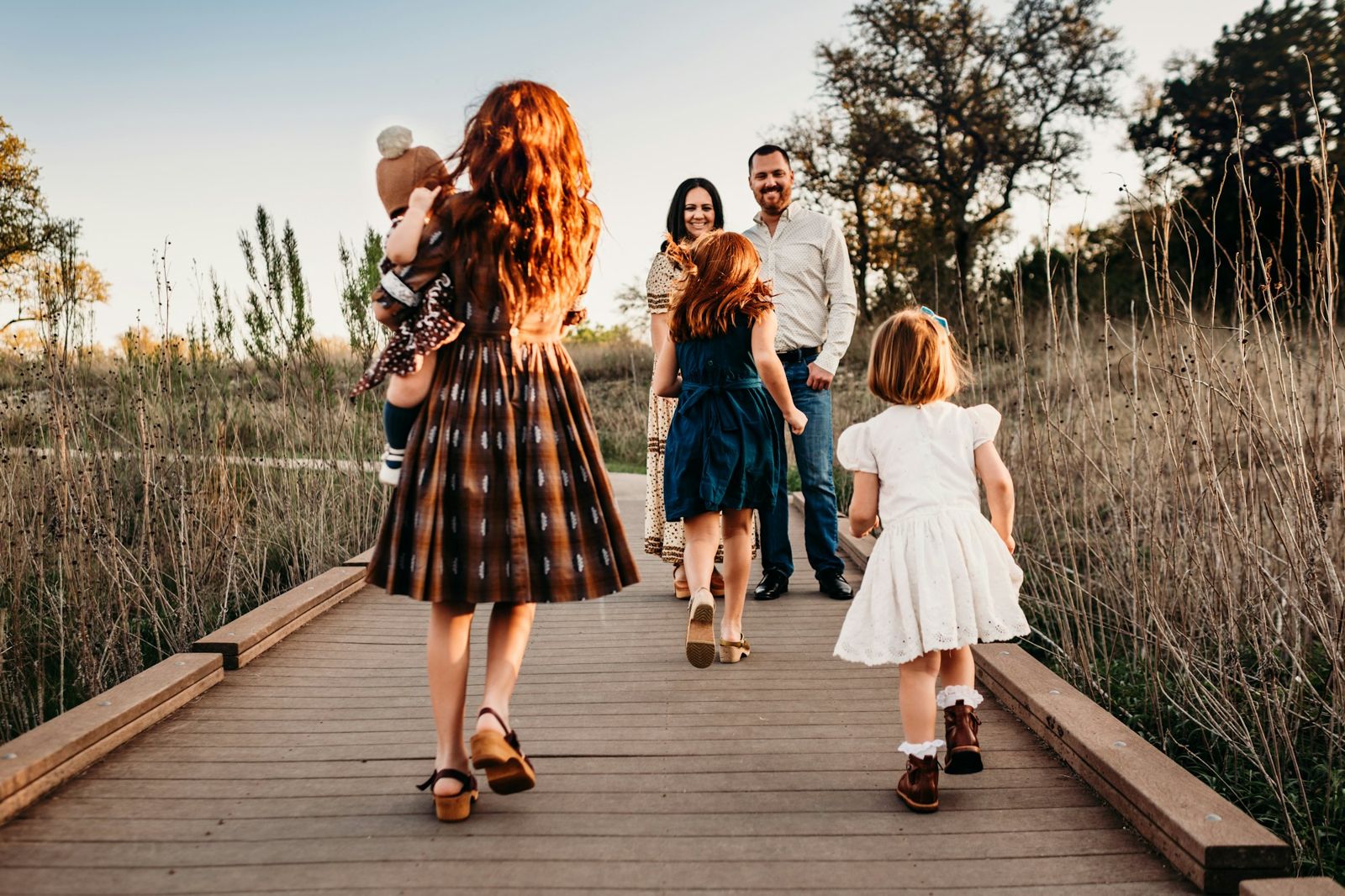 Family walking on a boardwalk at sunset