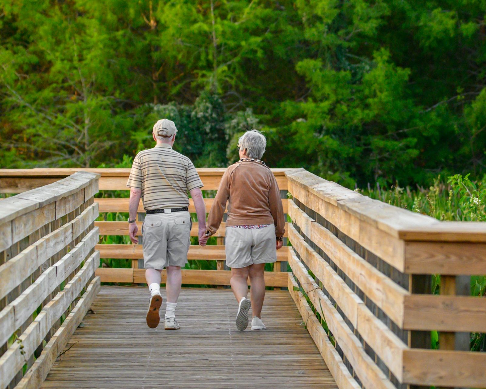 Older couple walking together on a wooden boardwalk
