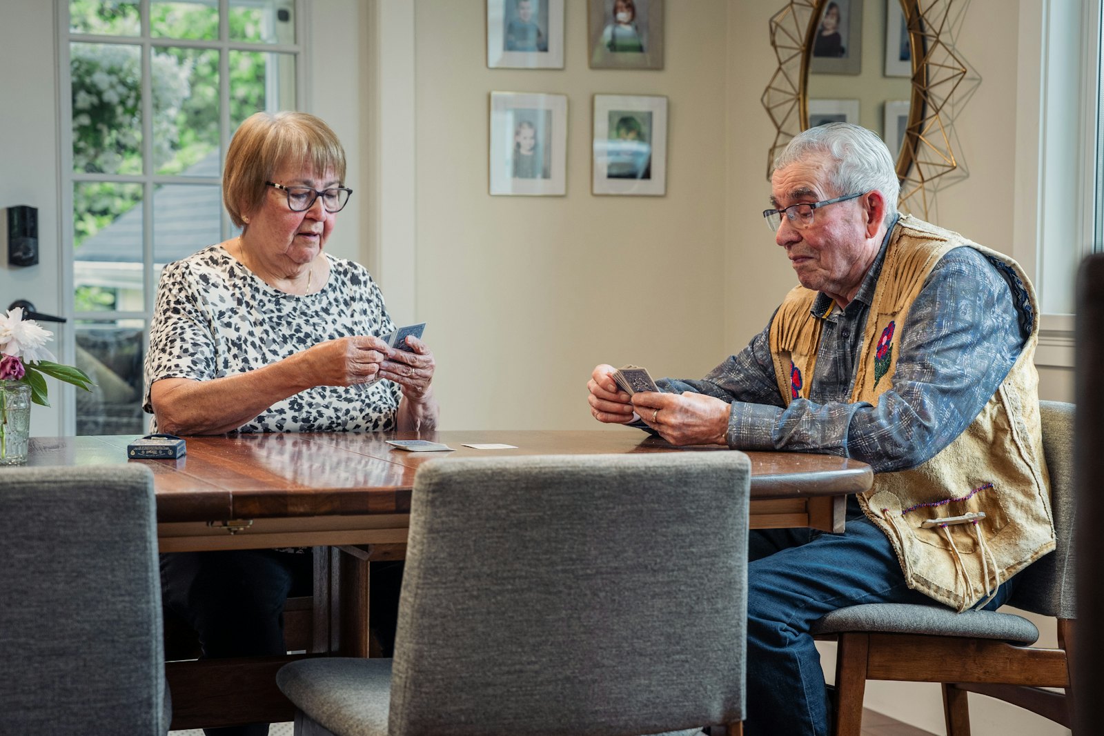 Older couple playing cards together at their kitchen table