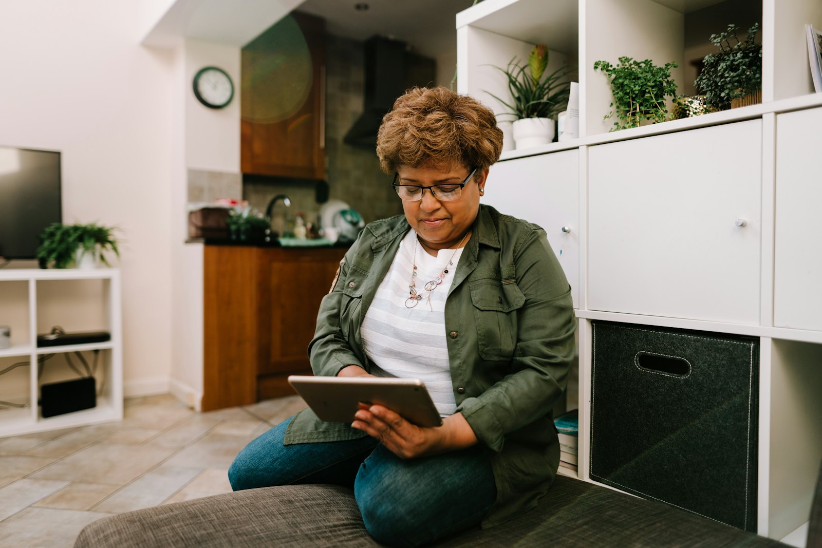Older woman reading on a tablet at home