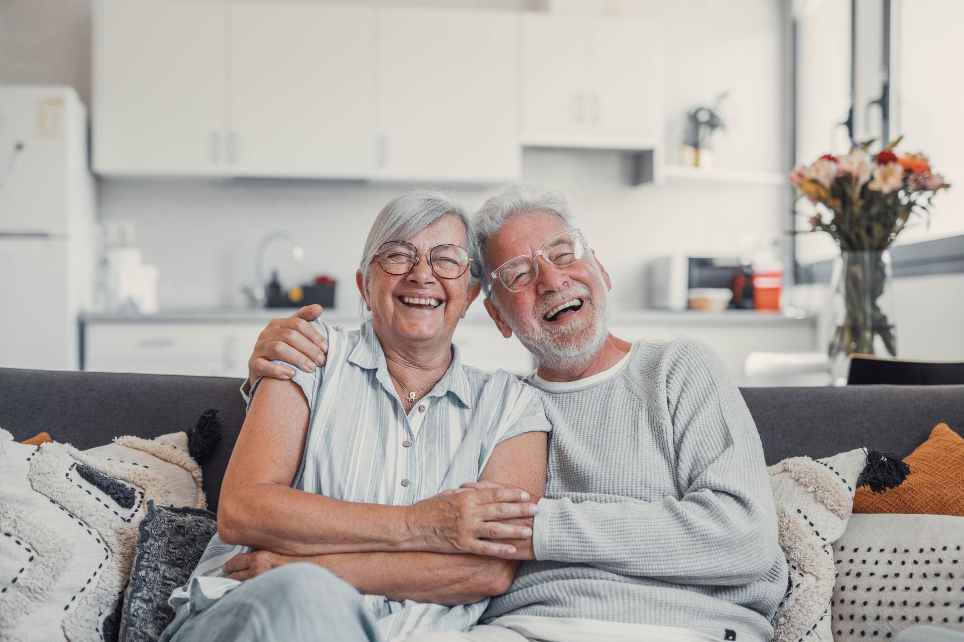 Smiling older couple sitting together on a couch