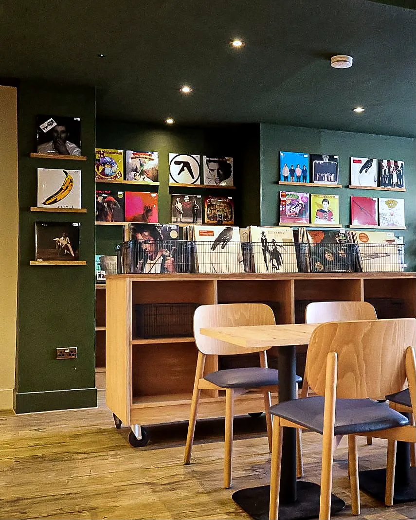 Record display rails and fitted timber shelving with seating at Lounge 33.