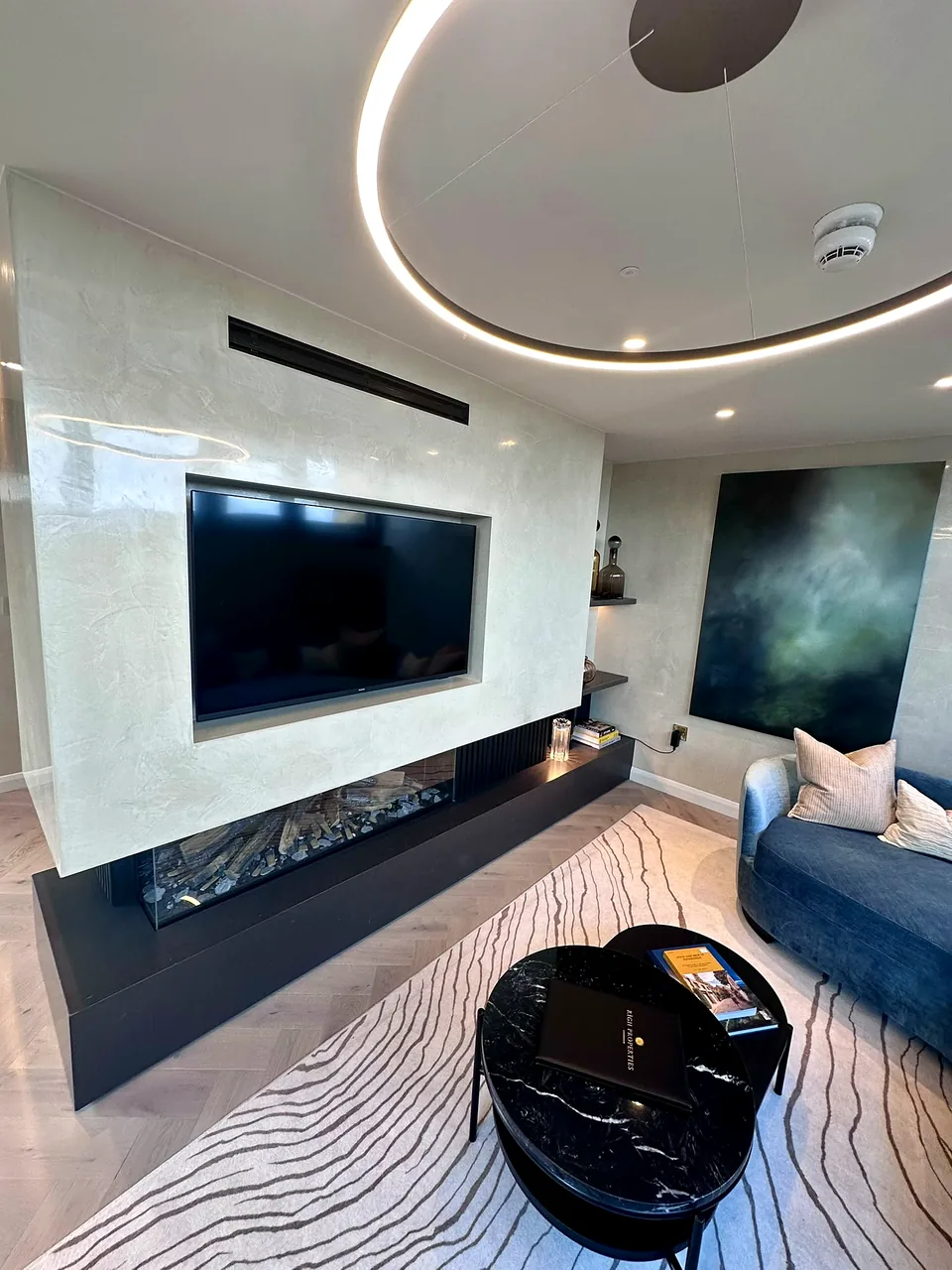 The living space at RIGH Residences, with an inset media wall and linear fire.