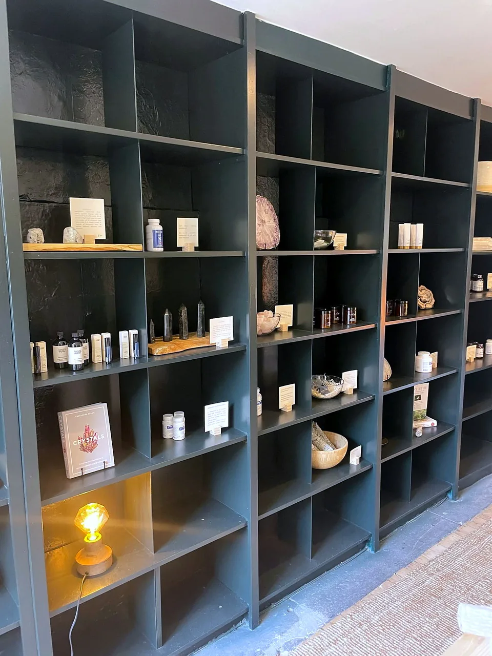 Bespoke black retail display joinery with integrated lighting at Solstice Wellness.