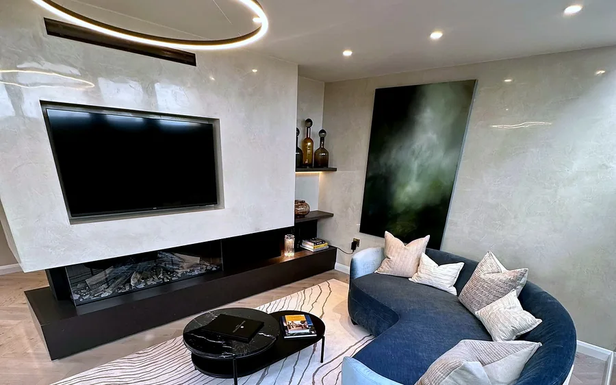 A completed high-end residential living room by CTD Scotland, with an inset media wall, linear fireplace and curved seating.