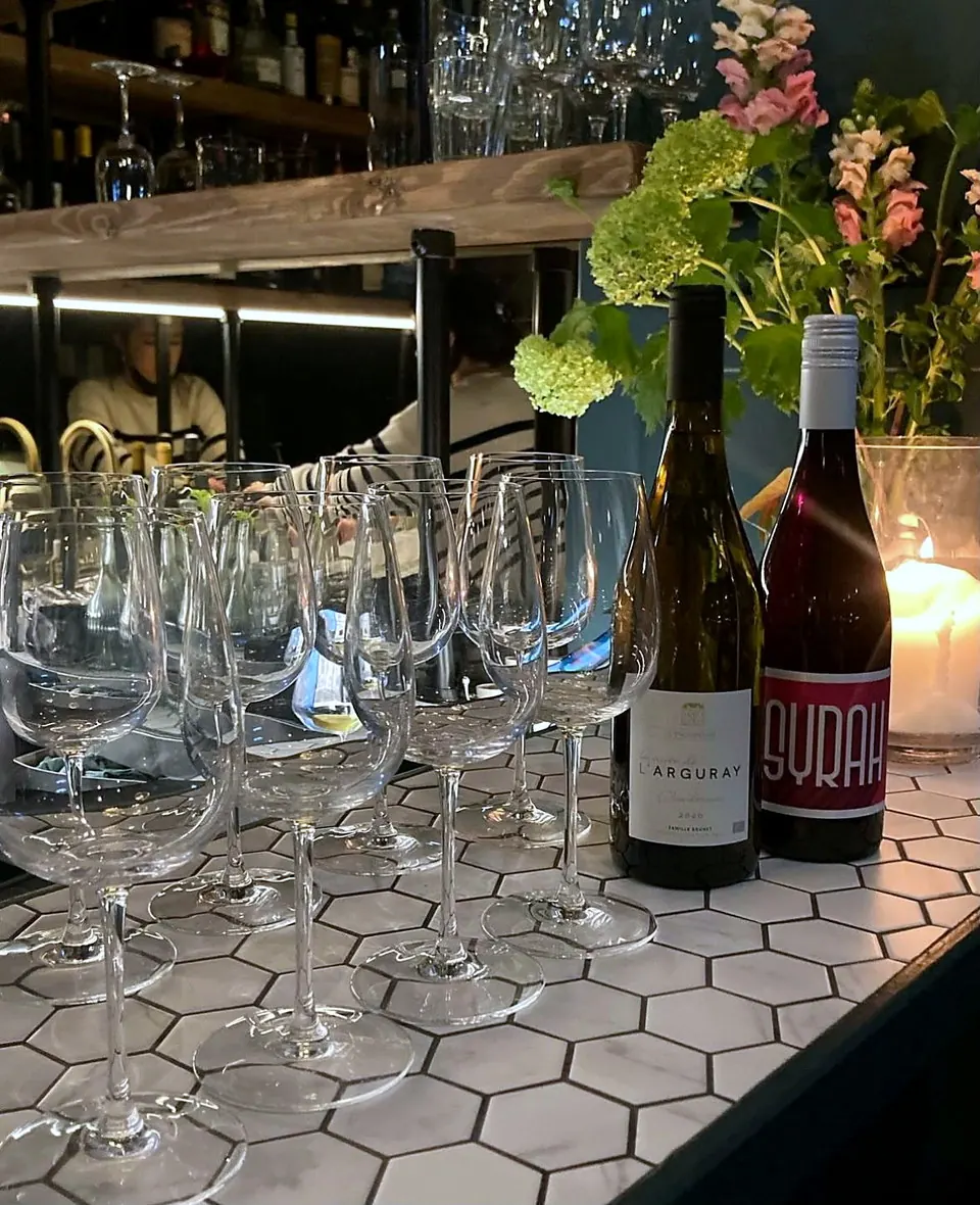 The hexagonal tiled bar top at Leftfield, set with glassware.
