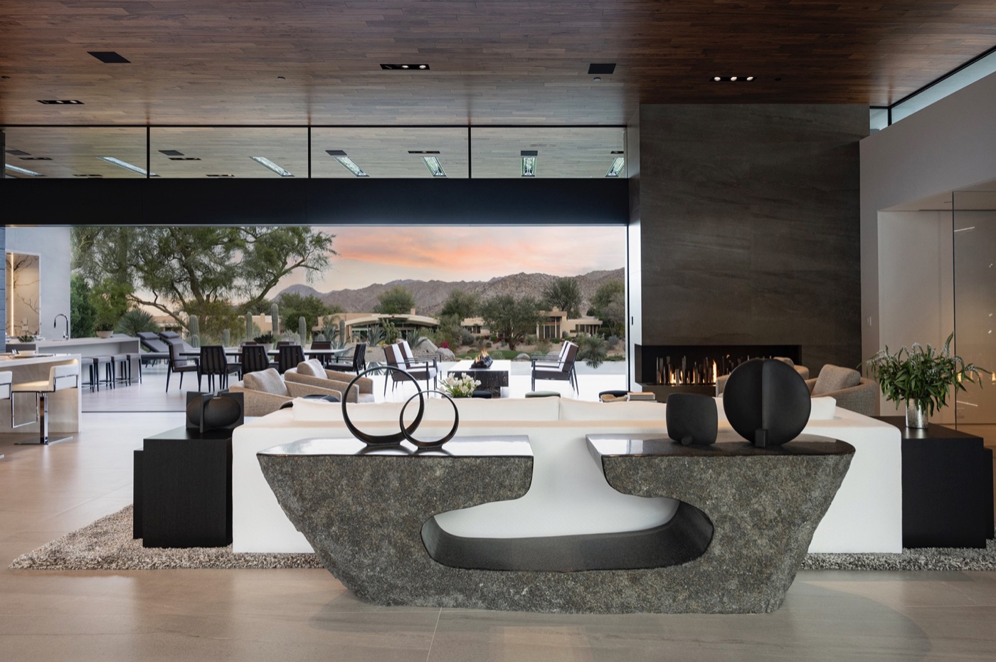 Great room with floor-to-ceiling glass and mountain views at dusk