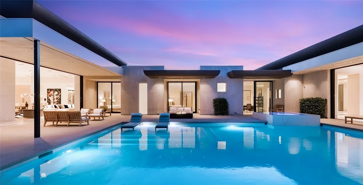 Courtyard pool at twilight with glowing indoor-outdoor living