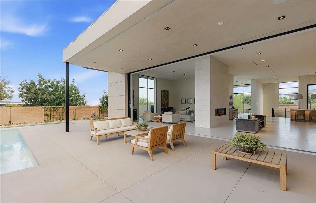Covered patio and open great room with retractable glass wall