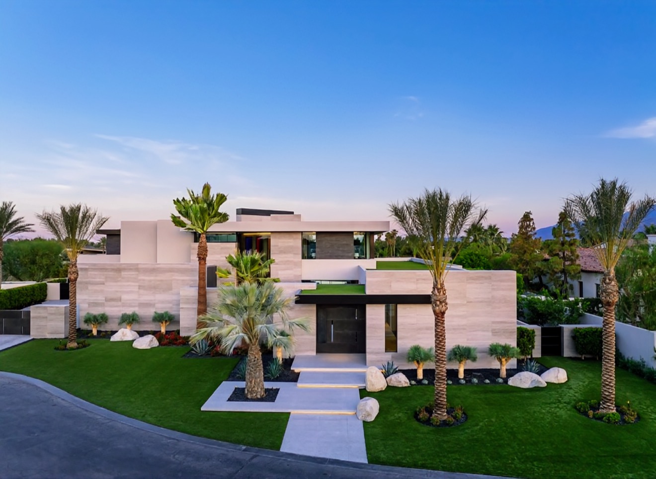 Modern two-story estate front elevation with palm-lined circular drive
