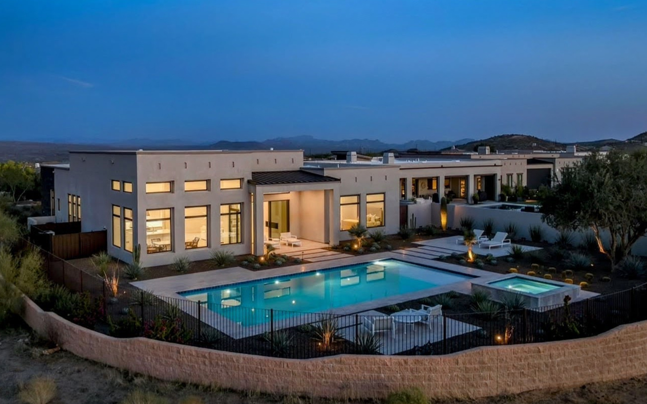 Desert estate at dusk with pool, spa and mountain views