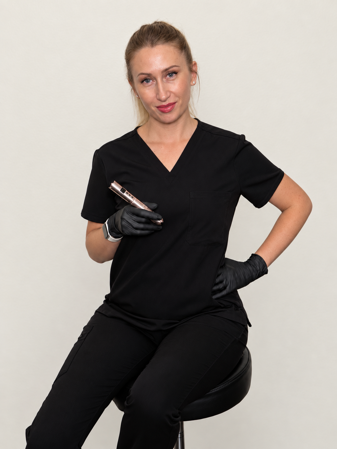 Iryna in black scrubs holding her PMU pen