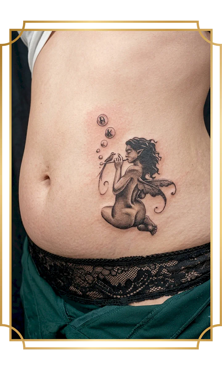 Fine line black and gray fairy tattoo blowing bubbles on the abdomen