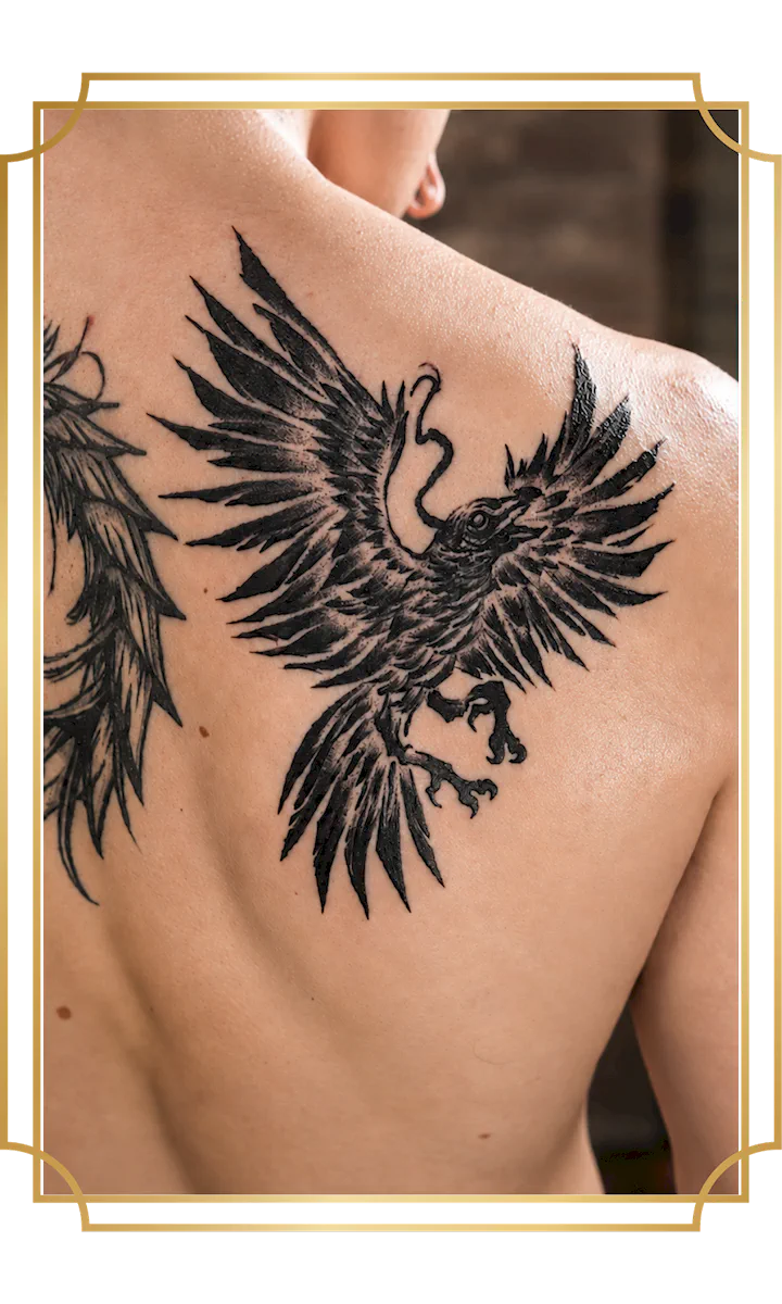 Blackwork raven tattoo with outstretched wings on the upper back