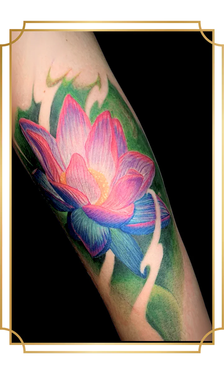 Full-color lotus forearm tattoo with glowing pink petals, purple and blue lower petals, and a saturated green botanical background by Alek the Saint