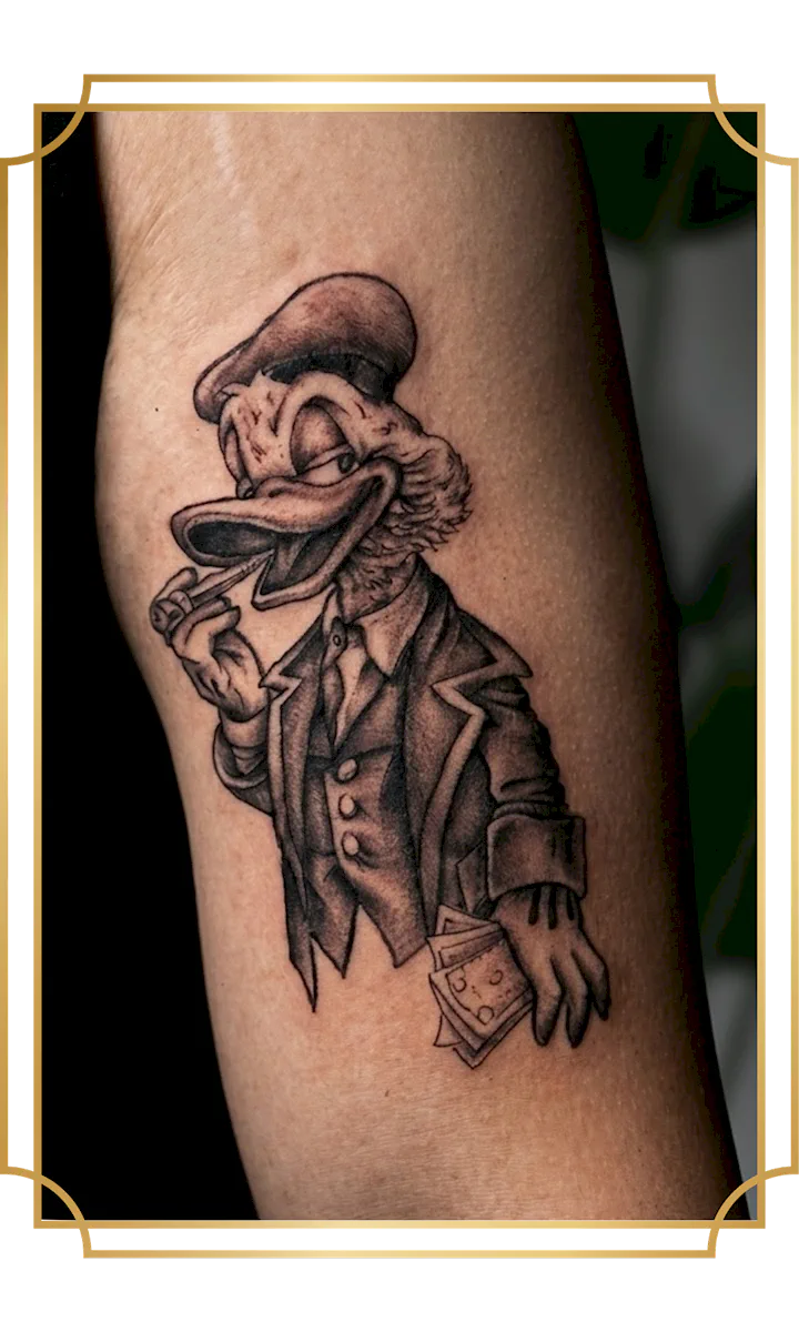 Black and gray Scrooge McDuck tattoo in a suit holding money and smoking a cigar on the bicep