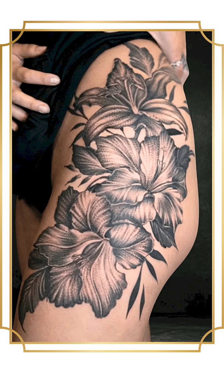 Blackwork floral tattoo with detailed flowers and leaves on the thigh