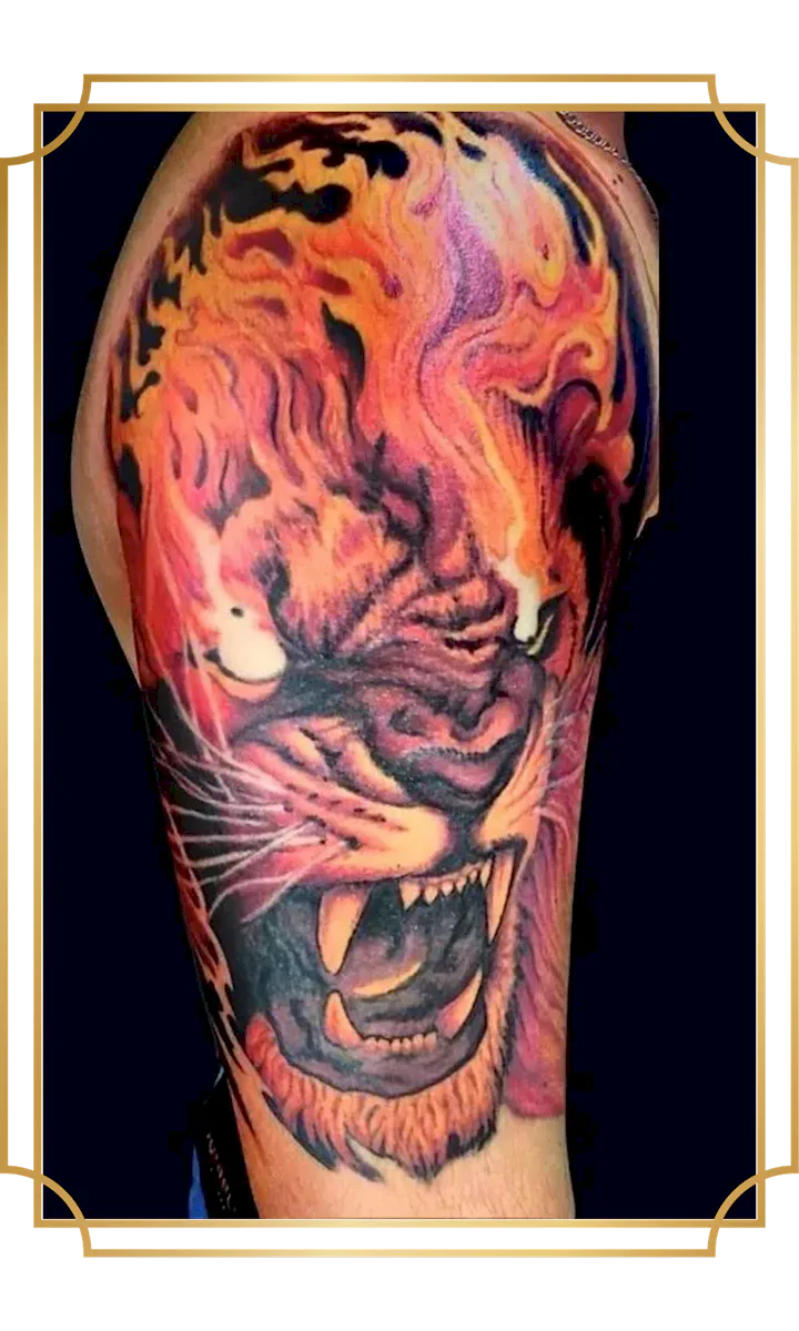 Full-color roaring tiger upper-arm tattoo surrounded by flowing orange, red and purple flames by San Marcos tattoo artist Alek the Saint