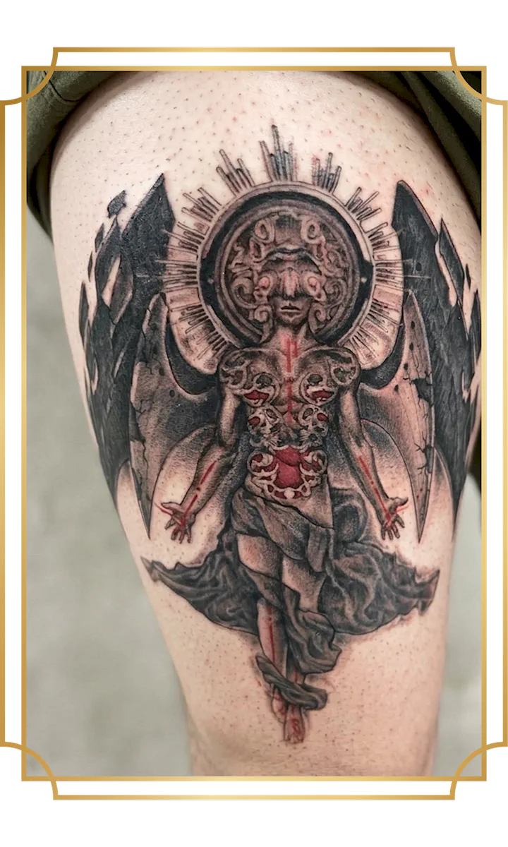 black and gray stone angel tattoo with red elements on the thigh