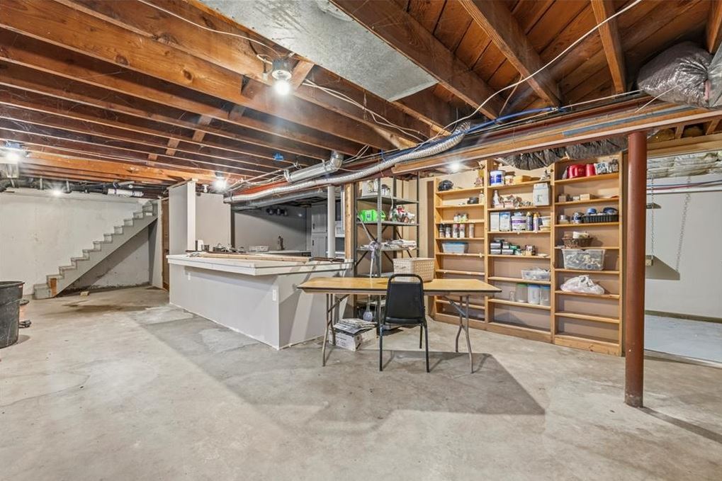 Unfinished basement with secondary kitchen and storage shelving in updated ranch home Excelsior Springs MO with room to finish near Kansas City