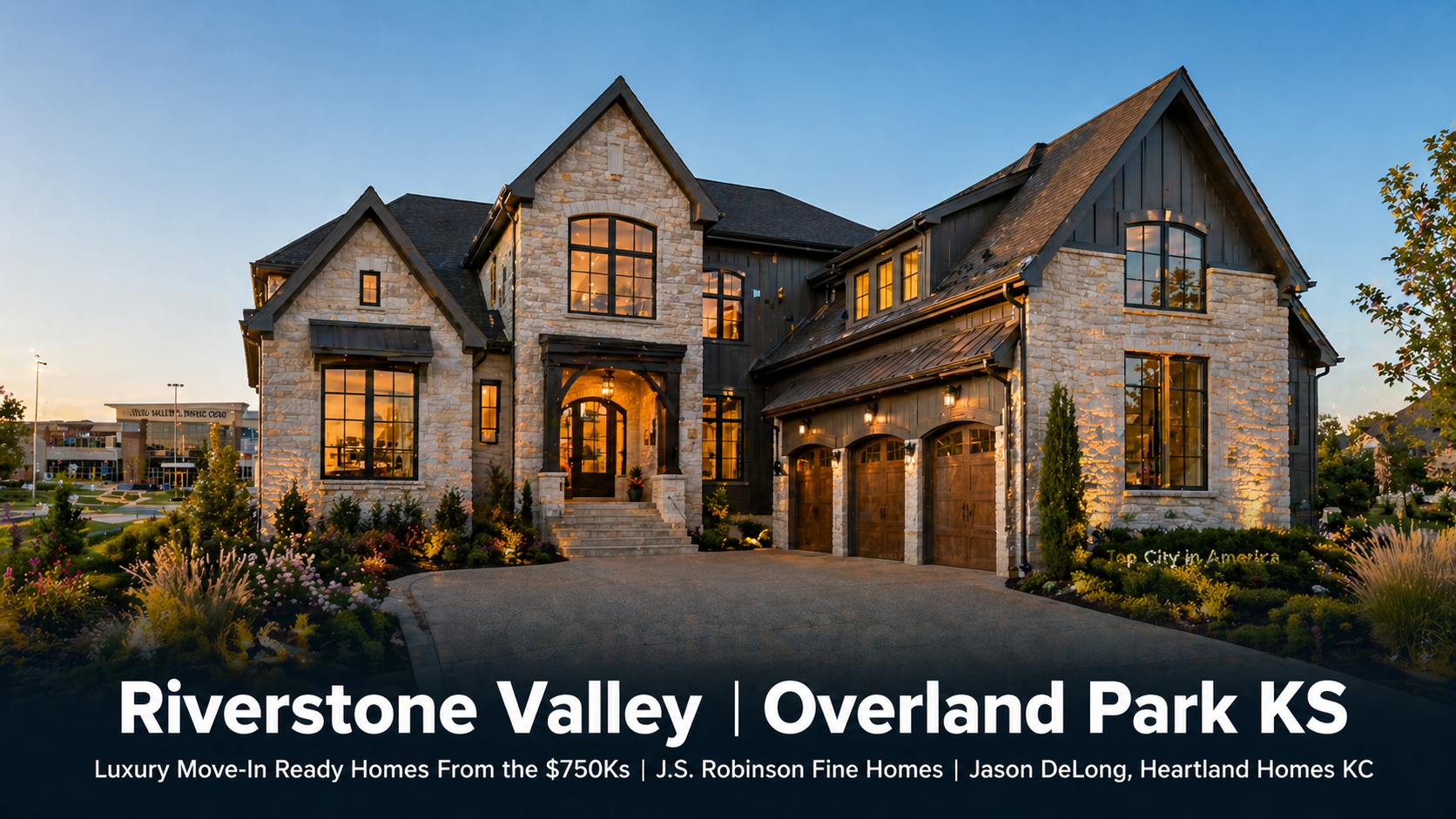 Luxury J.S. Robinson Fine Homes model home at Riverstone Valley in Overland Park KS featuring limestone and dark fiber cement exterior with oversized windows and Blue Valley school campus visible in the background representing move-in ready inventory from the $750,000s by Jason DeLong Heartland Homes KC.