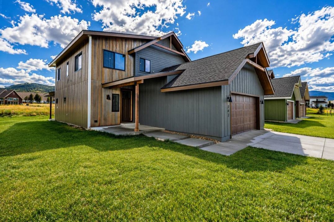 Front exterior of the Modern Rustic Mountain Retreat in Granby Colorado featuring corrugated metal and board and batten siding with timber beam accents and attached garage near Grand Elk Golf Course and Winter Park Front exterior of the Modern Rustic Mountain Retreat in Granby Colorado featuring corrugated metal and board and batten siding with timber beam accents and attached garage near Grand Elk Golf Course and Winter Park