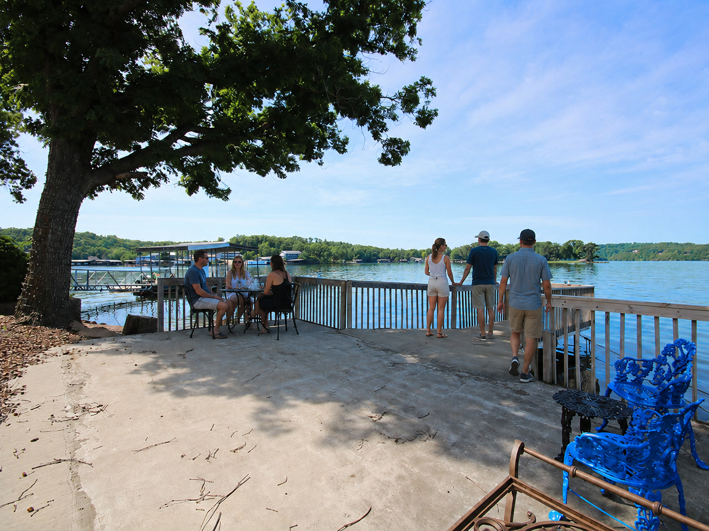 Lake Ozark waterfront patio with guests relaxing by the water, dock access, lake views, and a walkable location near local entertainment.