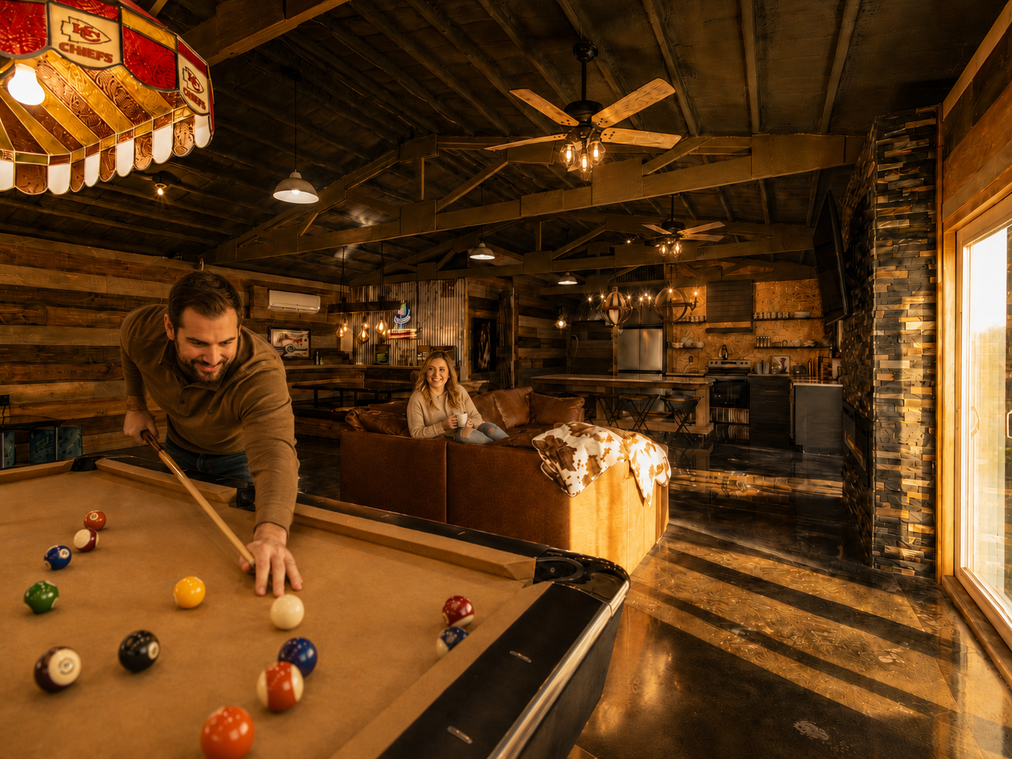 Rustic luxury barn stay interior with a guest playing billiards, cozy leather seating, warm golden-hour light, and farmhouse kitchen at Free Bird Farms in Missouri. Rustic luxury barn stay interior with a guest playing billiards, cozy leather seating, warm golden-hour light, and farmhouse kitchen at Free Bird Farms in Missouri.