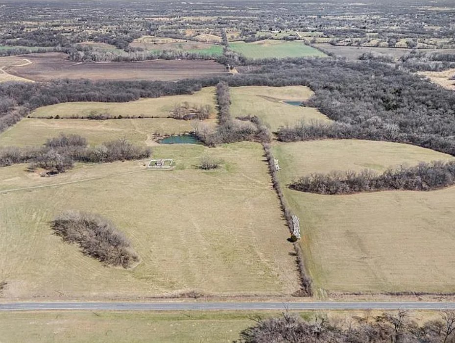 Aerial view of 38.26 acres at 18211 Plattsburg Road in Holt Missouri with open pasture, pond, tree lines, and road frontage