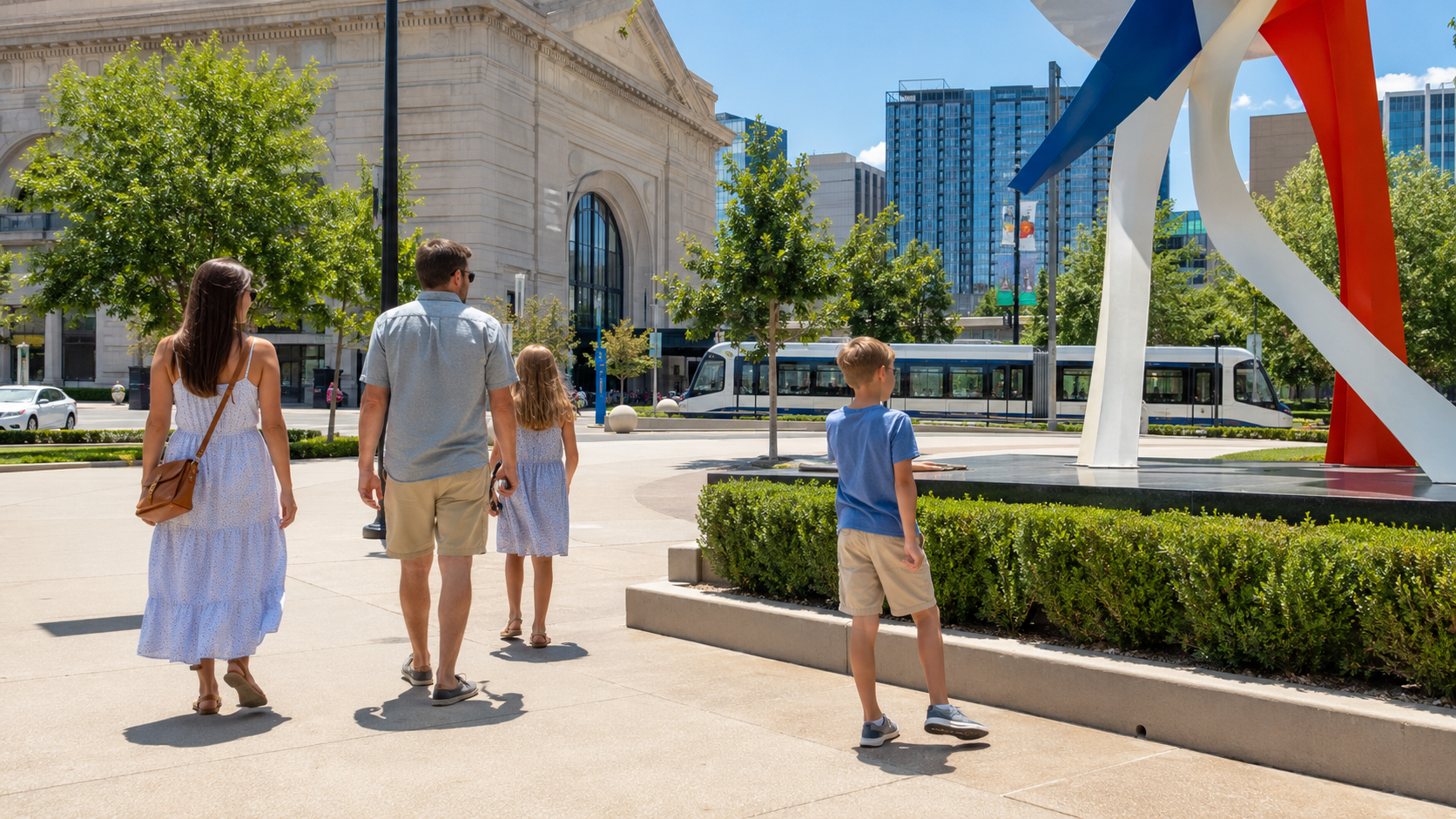 Family walking through Crown Center in Kansas City near Union Station, public art and the KC Streetcar on a sunny summer afternoon.