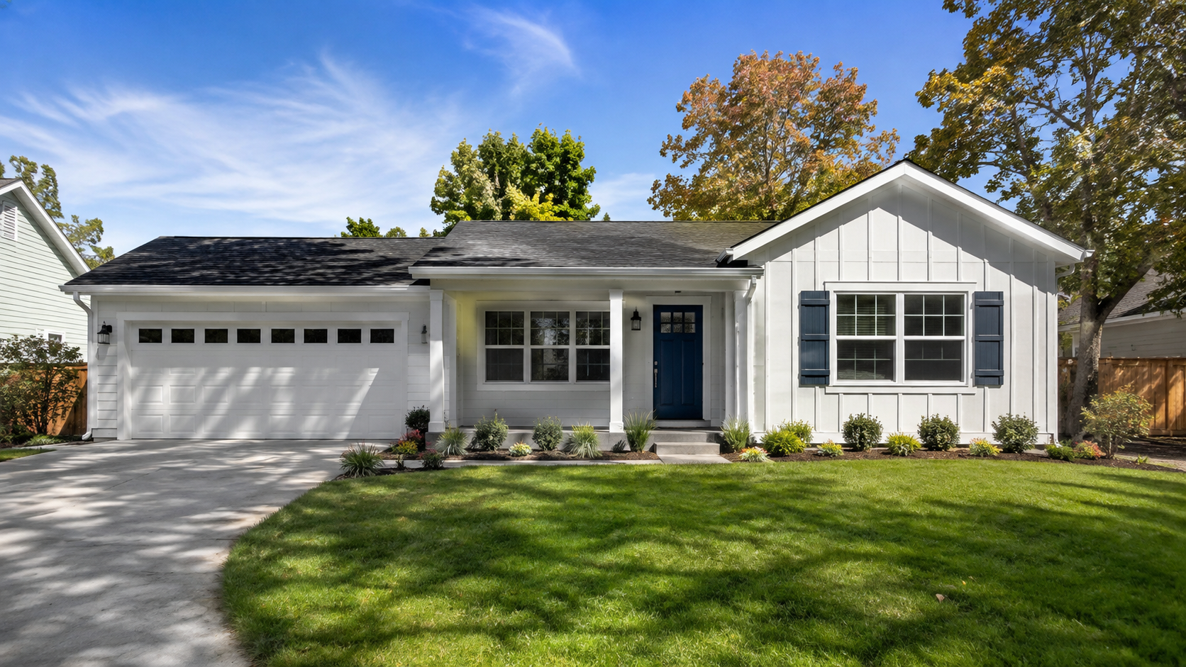 Freshly updated suburban home with new white exterior paint, a bold blue front door, and simple landscaping that adds resale value. Freshly updated suburban home with new white exterior paint, a bold blue front door, and simple landscaping that adds resale value.