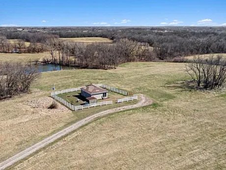 Aerial view of 38.26 acres at 18211 Plattsburg Road in Holt, Missouri, showing open land, a pond and an existing utility structure Aerial view of 38.26 acres at 18211 Plattsburg Road in Holt, Missouri, showing open land, a pond and an existing utility structure
