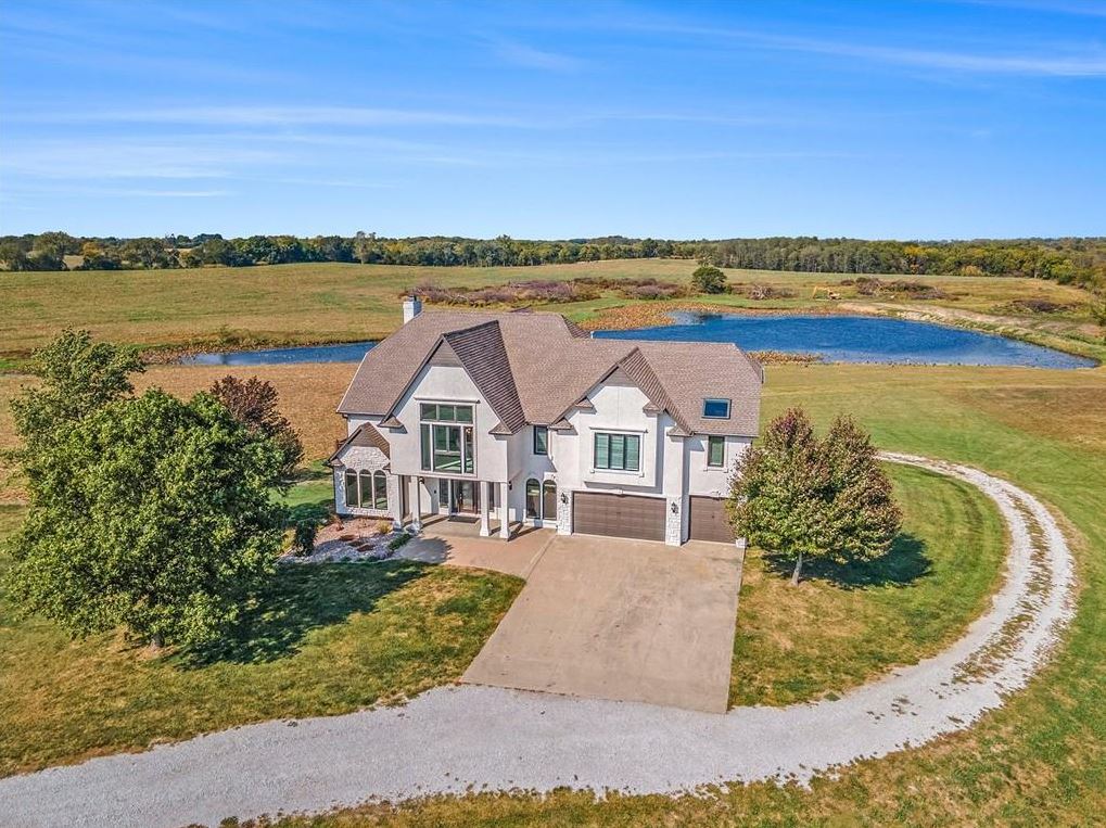 Aerial view of the estate at 2600 NW 108th Street in Kansas City, Missouri, with a large home, 20 acres and a pond Aerial view of the estate at 2600 NW 108th Street in Kansas City, Missouri, with a large home, 20 acres and a pond
