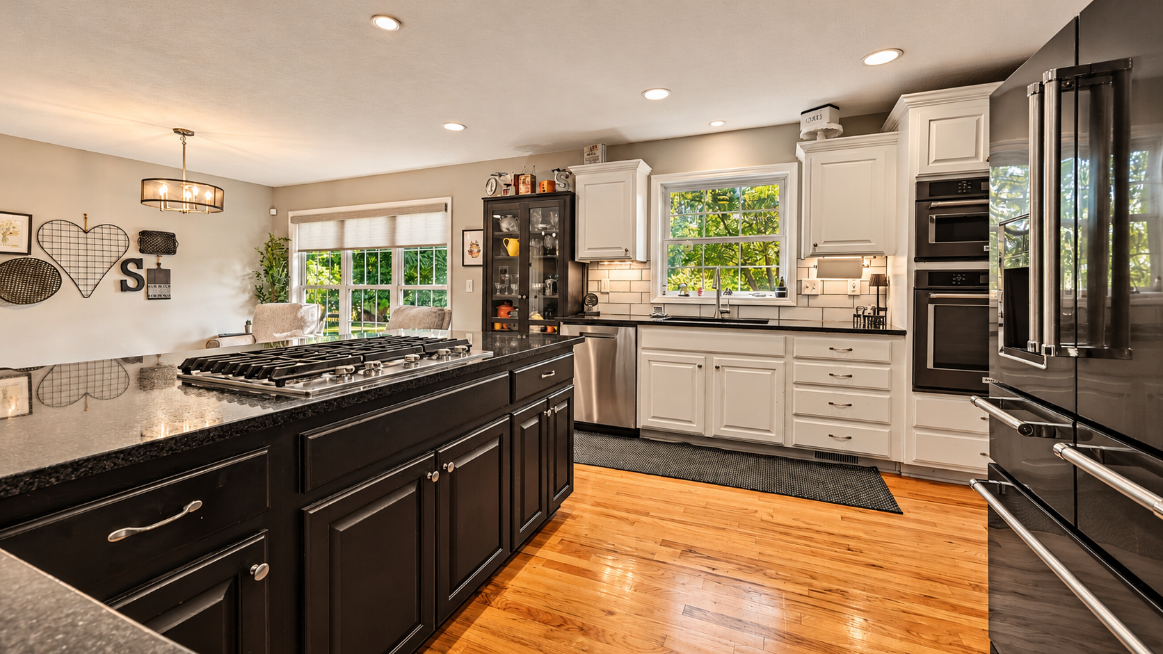Updated kitchen with granite countertops, a black island, white cabinets, and stainless steel appliances in Merriam KS.