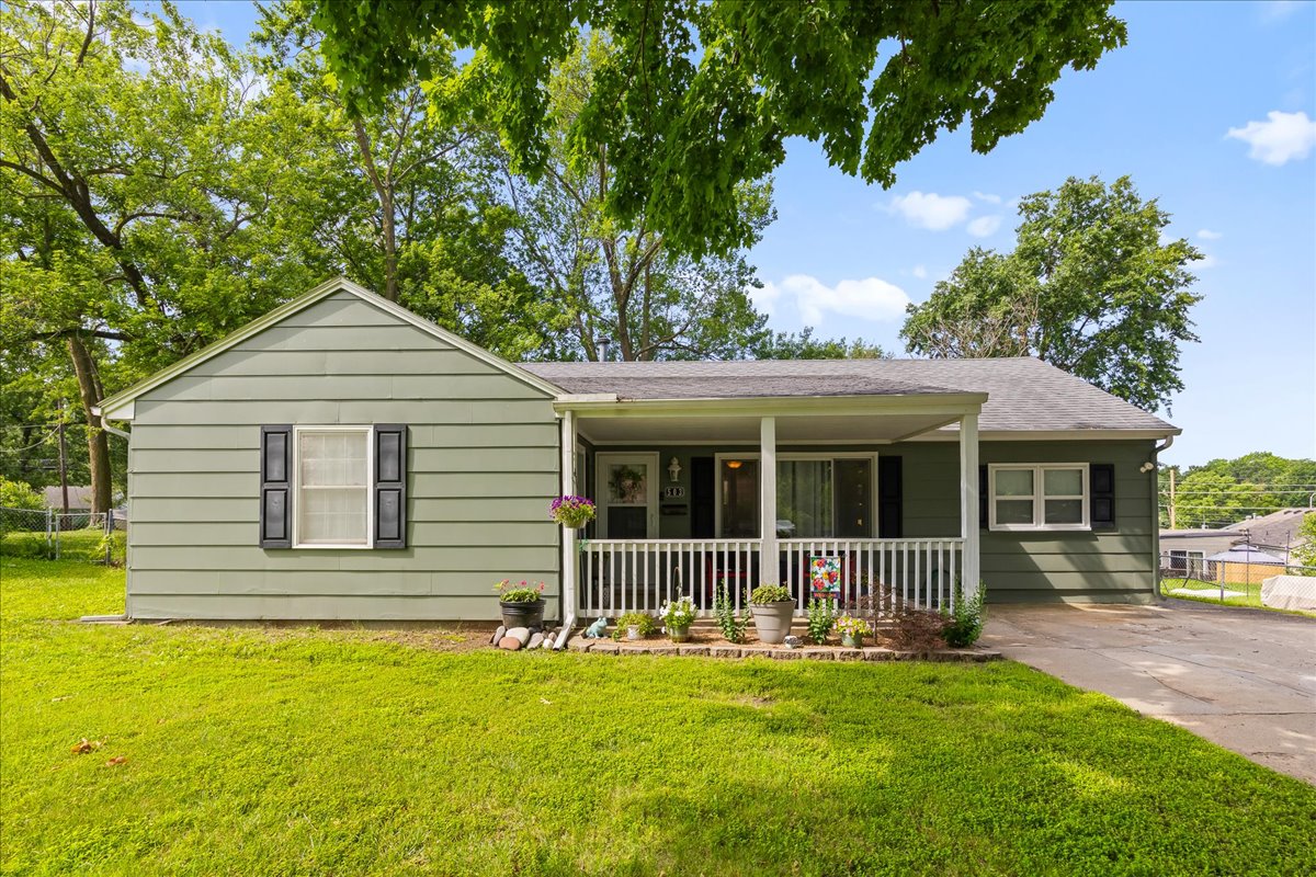 Covered front porch and concrete driveway of Gladstone ranch home