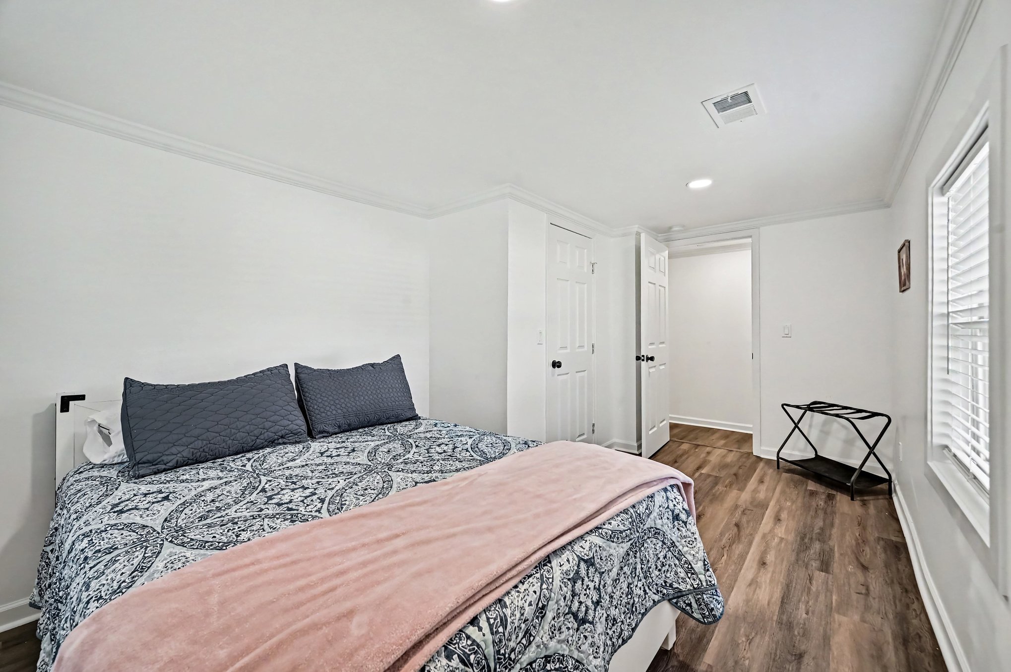 Bedroom with queen bed and two windows