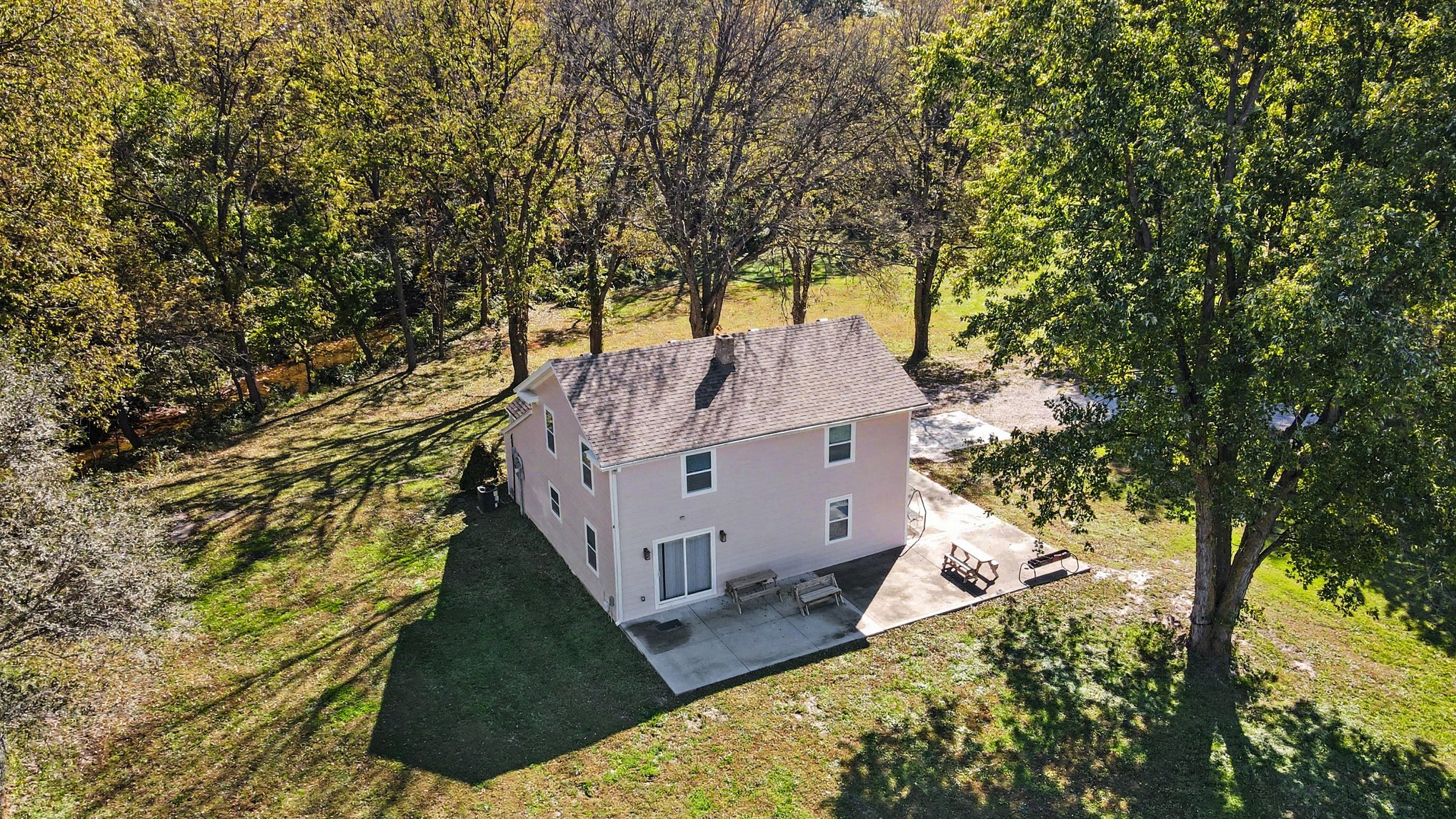 Aerial of the home, patio and wooded creek line