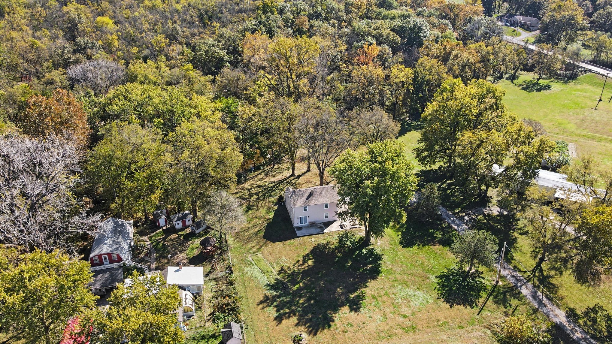Wide aerial of the property and surrounding woods