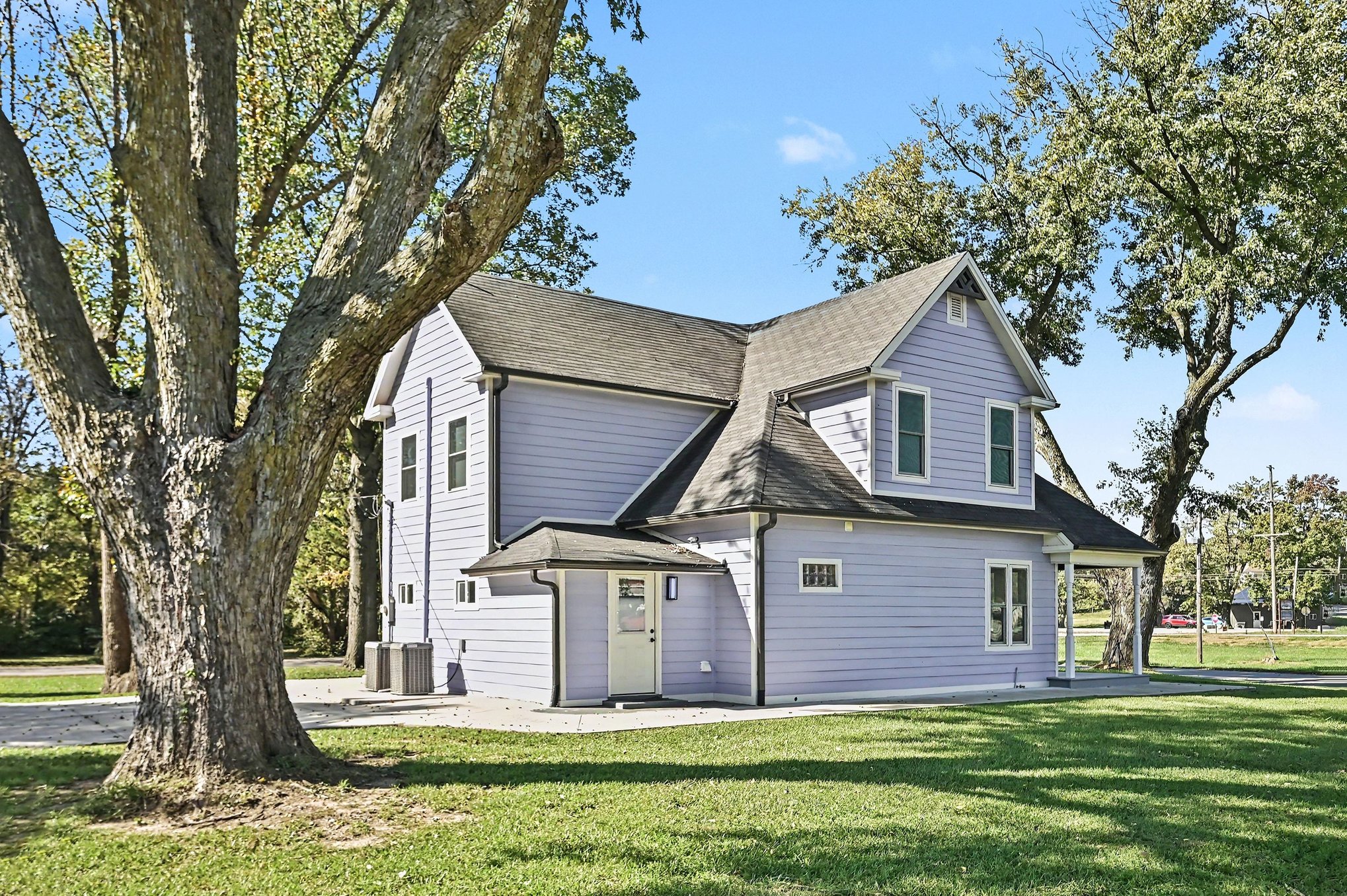 Side and rear of the home beneath a mature shade tree