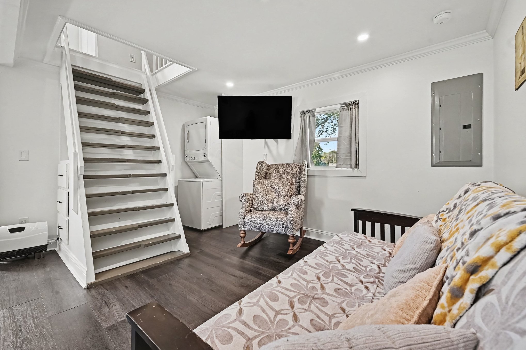 Guest house living area with stairs to loft and stacked laundry