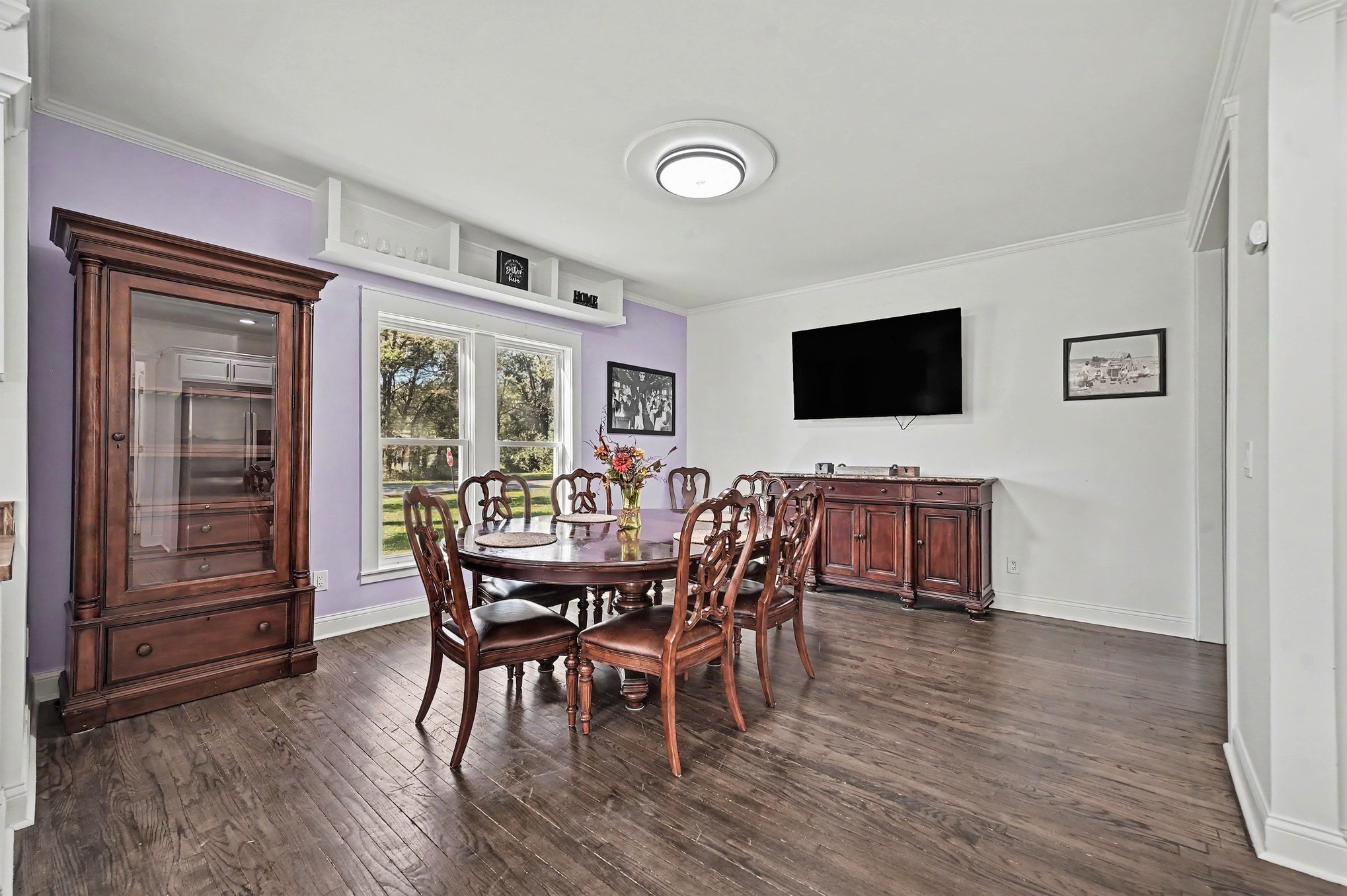 Dining room with seating for eight, built-in shelf and wall-mounted TV