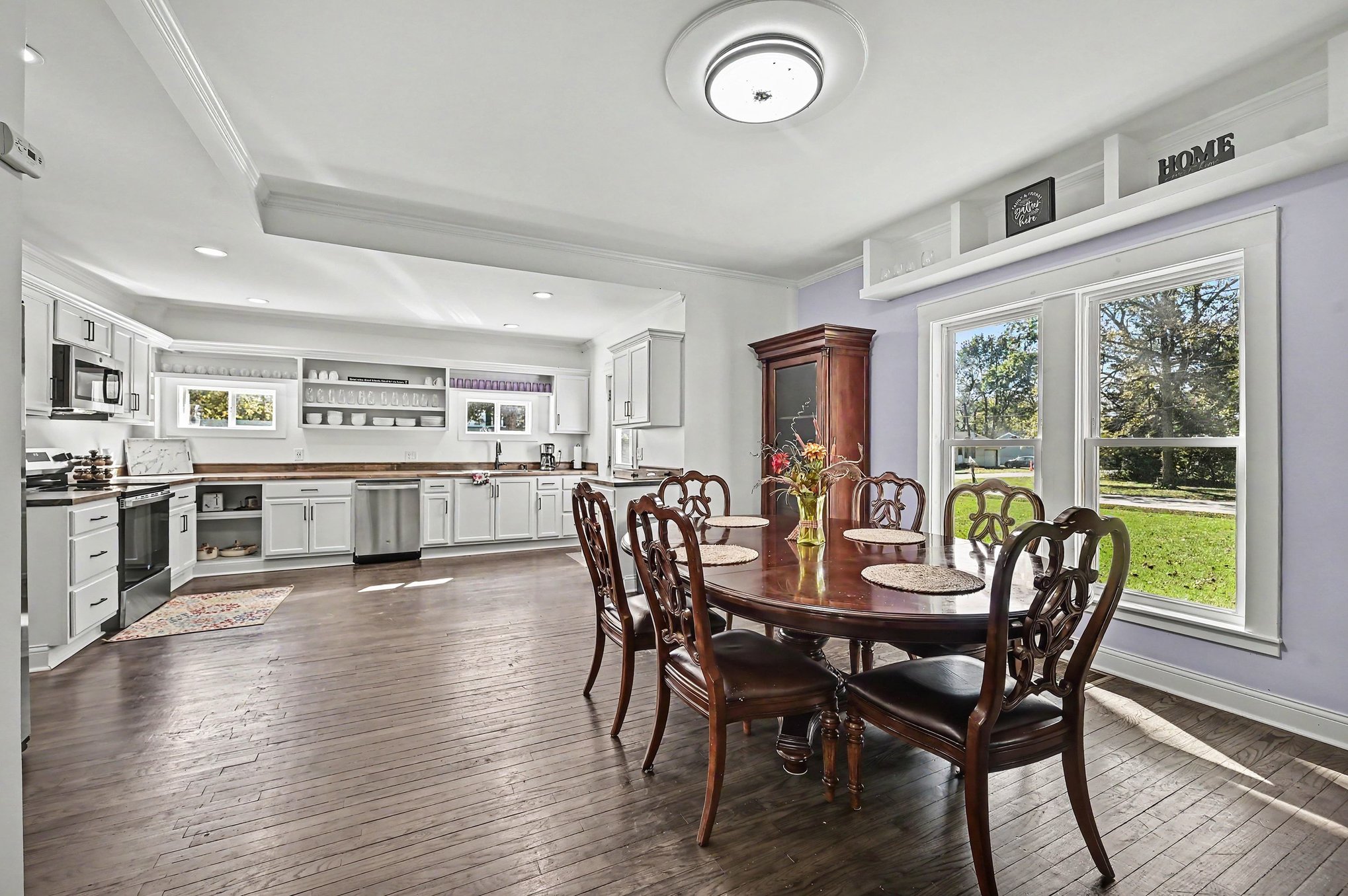 Main house open kitchen and dining room with refinished hardwood floors and a table for eight