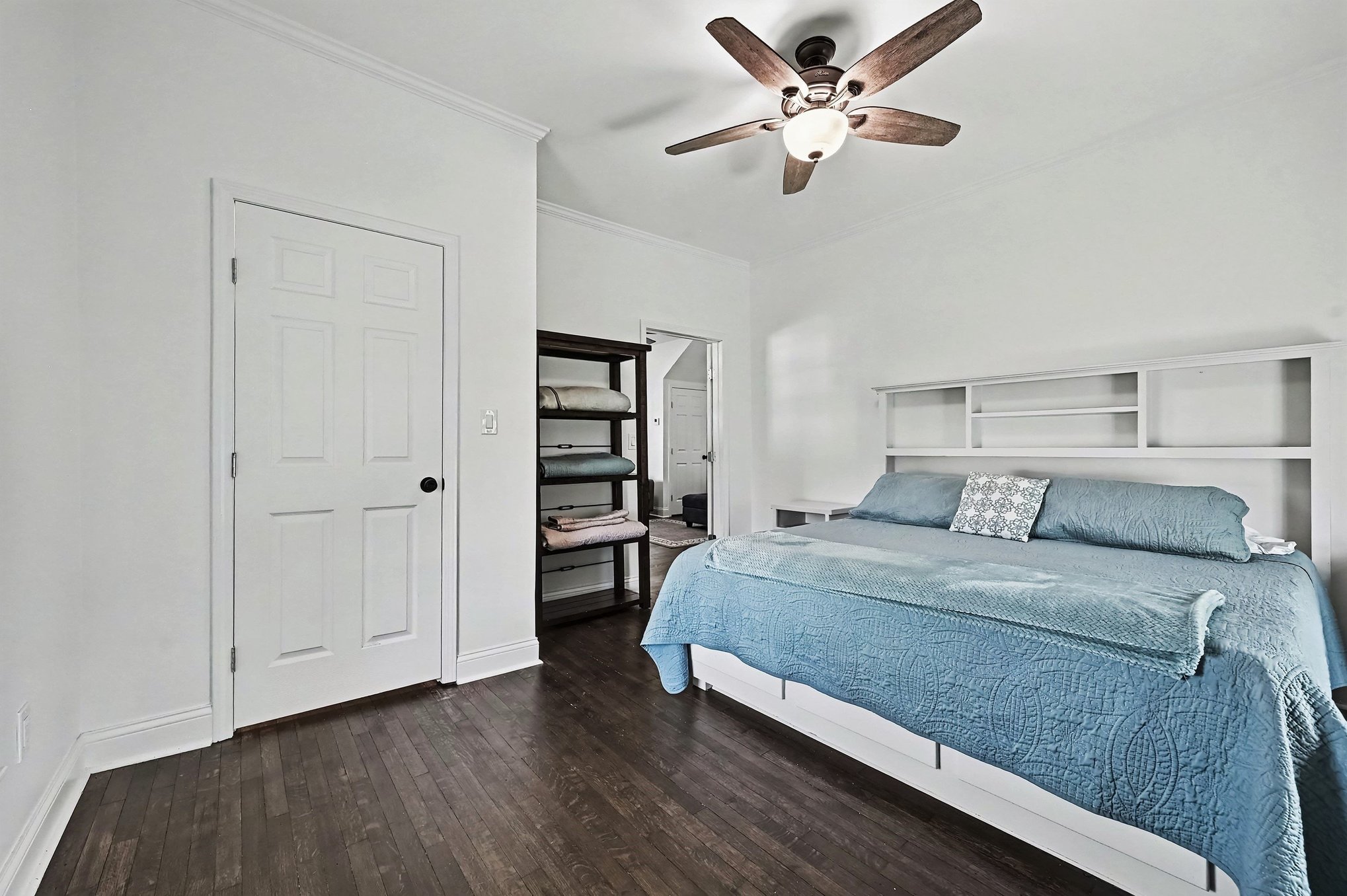 Main-level bedroom with built-in headboard and hardwood floors