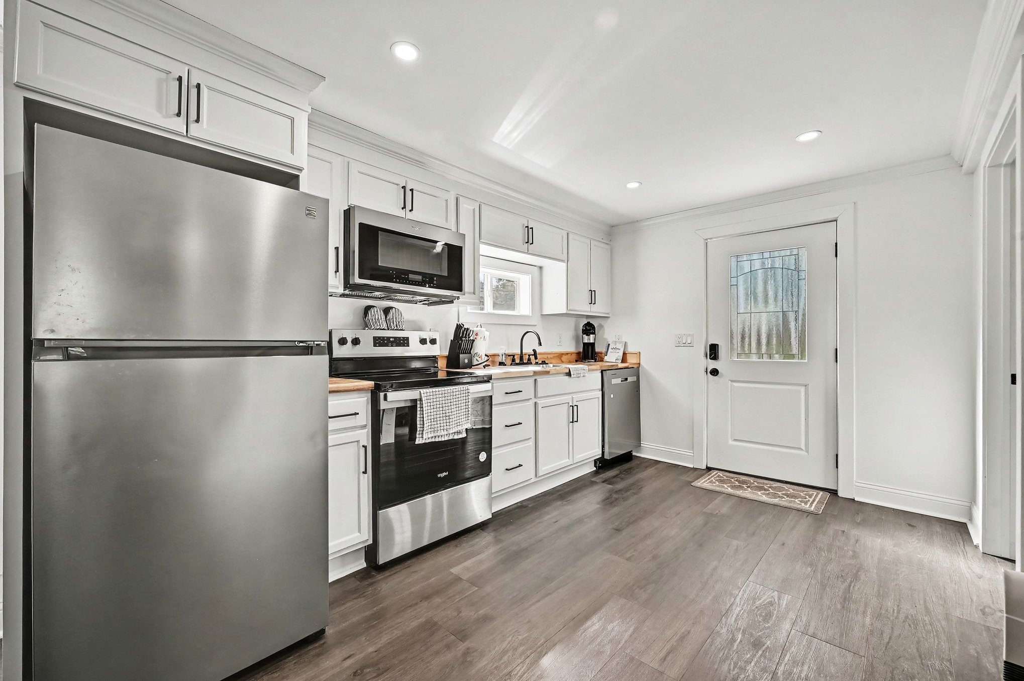 Guest house kitchen with stainless appliances and butcher-block counters