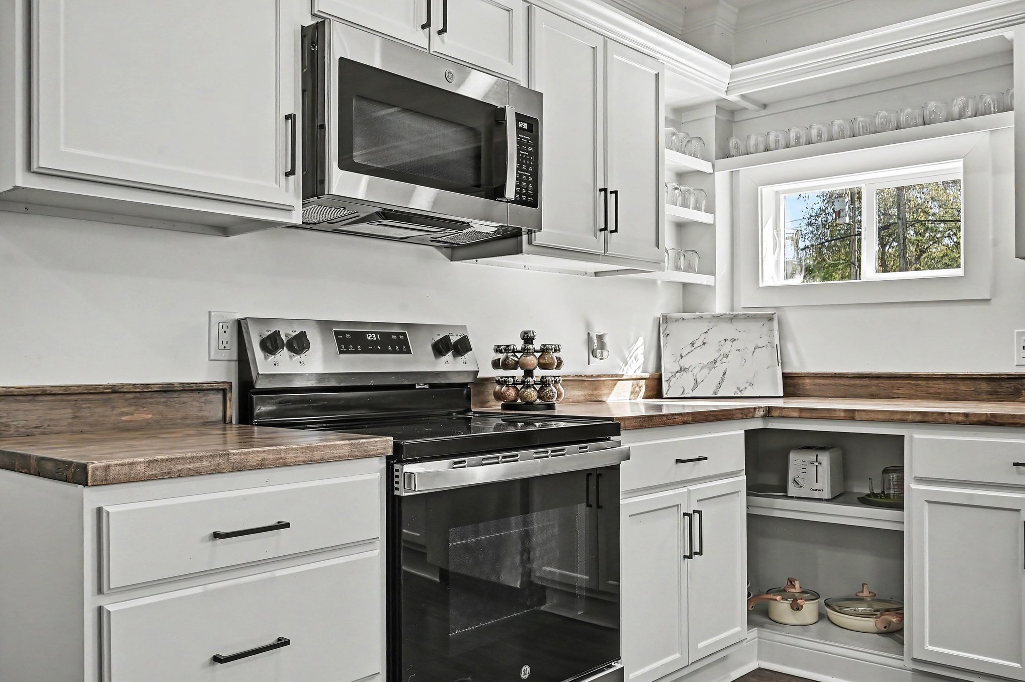Kitchen detail with stainless range, microwave and open shelves