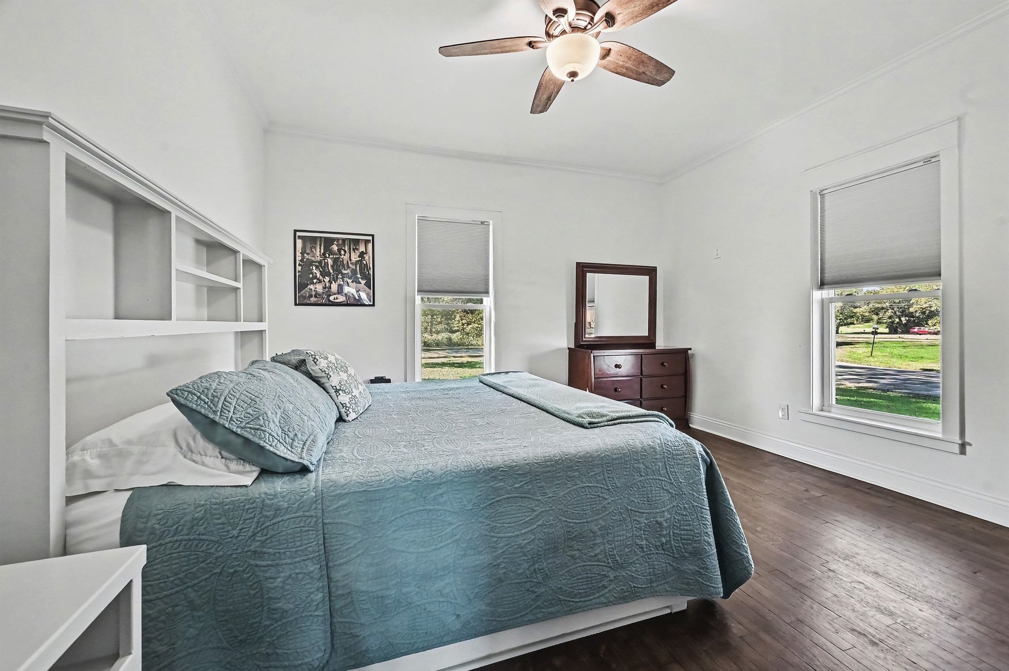 Main-level bedroom with two windows over the lawn