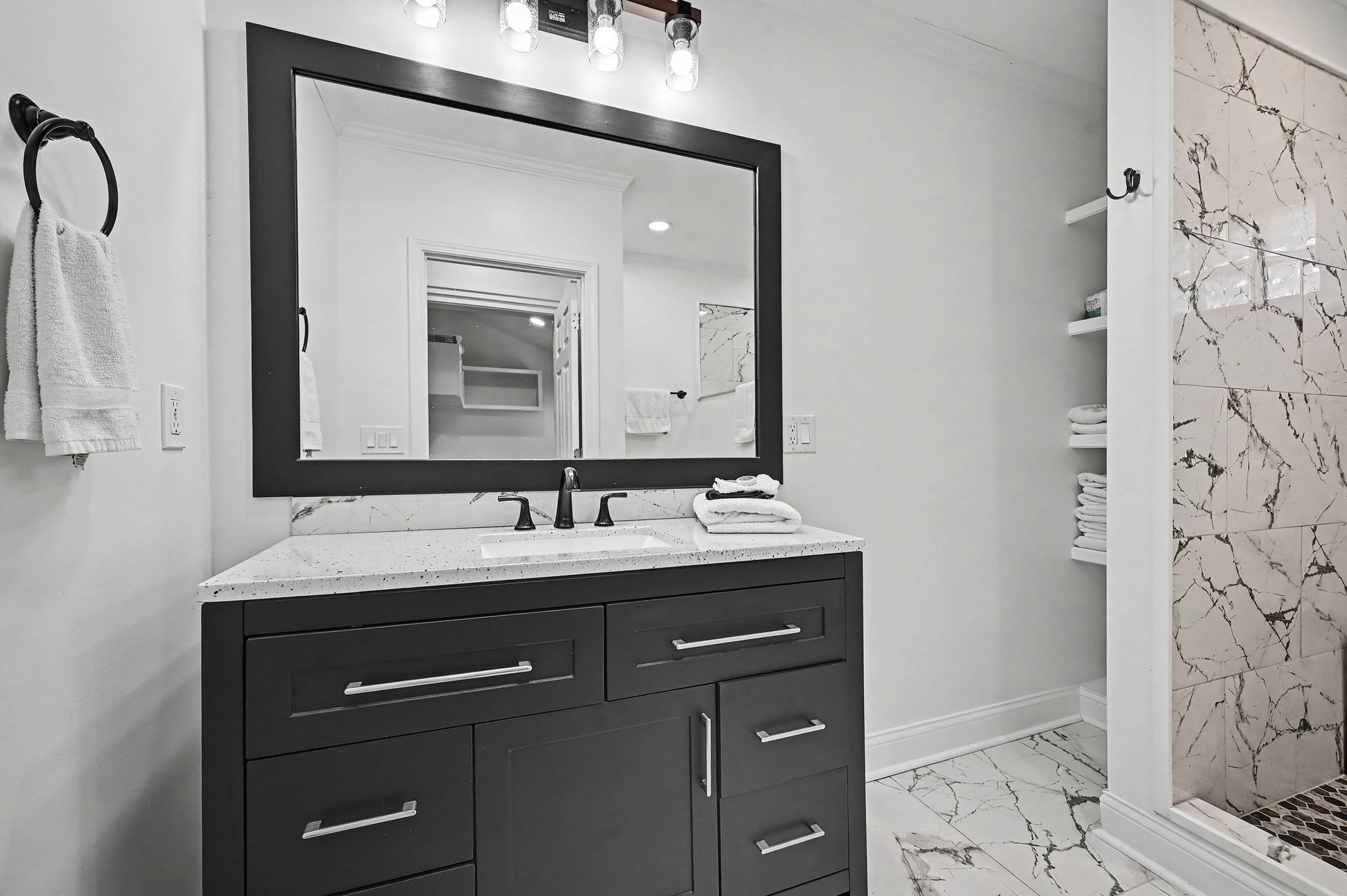Main-level bath vanity with quartz-look top and matte black fixtures