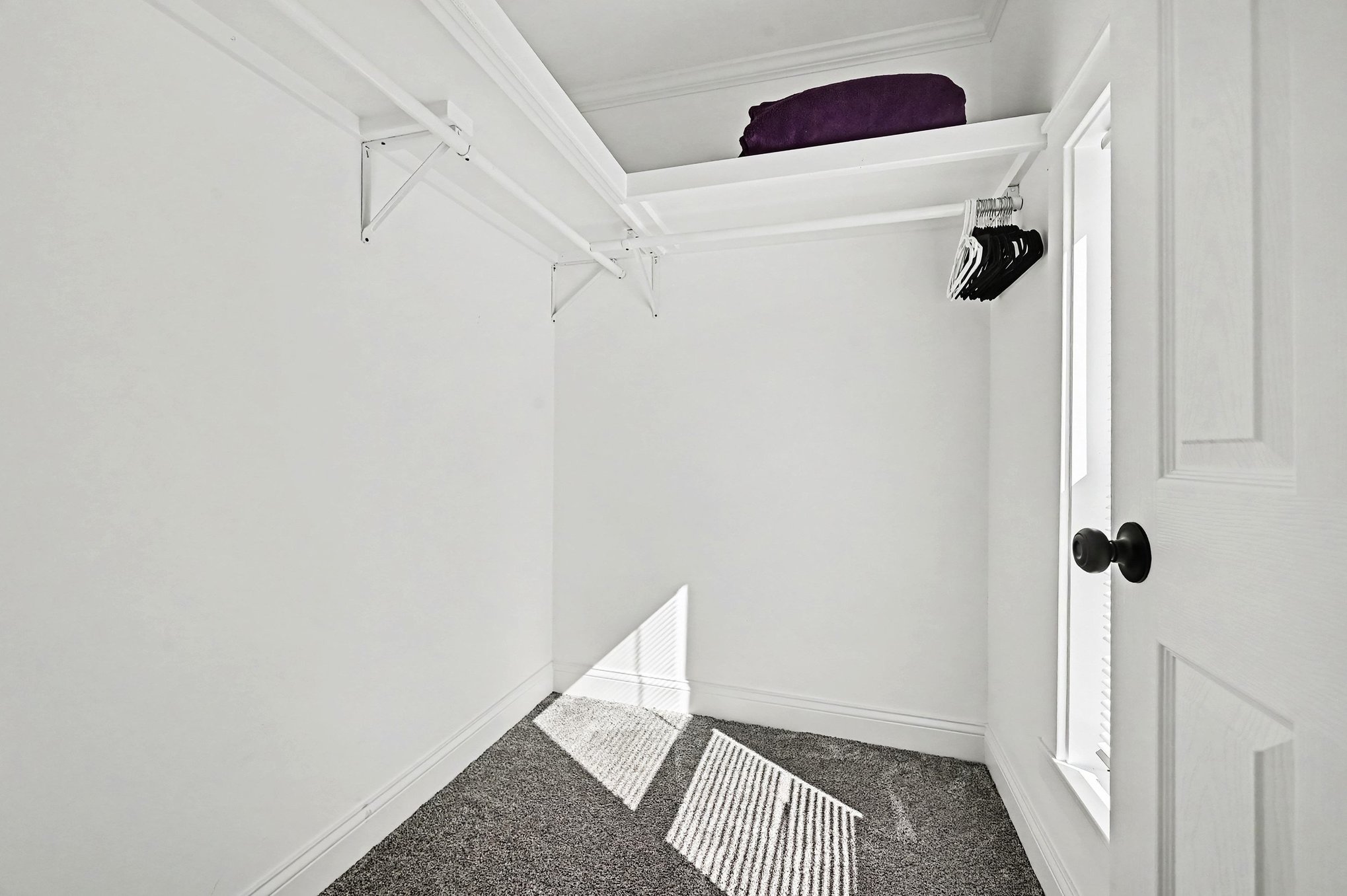 Walk-in closet with hanging rods and shelving