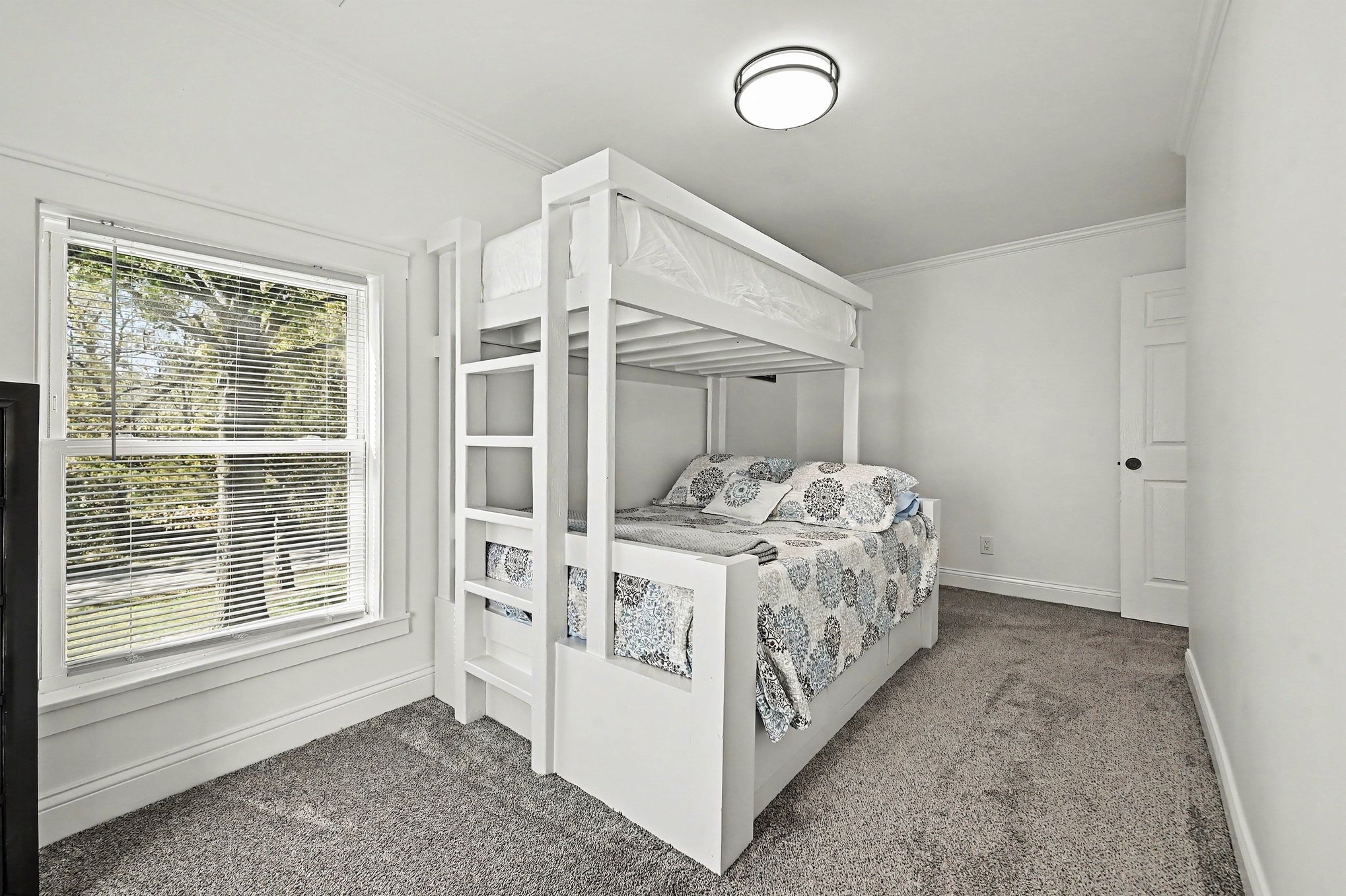 Bunk room with large window and storage drawers