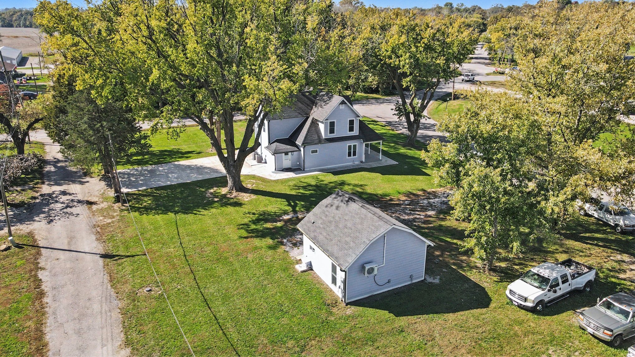 Aerial of the farmhouse, guest house and driveway under mature trees
